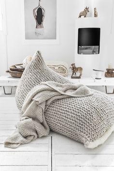 a blanket is laying on top of a bed with white sheets and pillows in the background