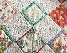 an old quilt with many different colors and designs on the front, along with flowers