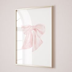 a pink bow hangs on the wall next to a window