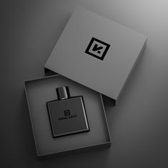 an open box with a black and white logo on it next to a bottle of cologne