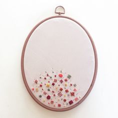 a white wall hanging with an embroidery pattern on it