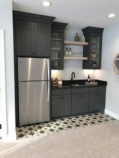 a kitchen with black cabinets and silver appliances