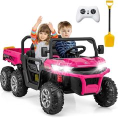 two children riding in a pink toy truck with remote controls and steering wheelie control