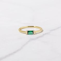 Sweet, simple, and dainty ring. Perfect for a minimalist look, or for stacking. Made of 925 Sterling Silver We use a THICK, DURABLE 14k Gold or Rhodium plating - for a piece that will last you years to come! Available in sizes 4-10 Ring Width: 1.3mm Emerald stone is made of the highest grade cubic zirconia for an authentic look! Nickel-Free & Hypoallergenic Also available in all Birthstone colors! Baguette Ring, Chunky Earrings, Birthstone Colors, Demi Fine Jewelry, Initial Jewelry, Emerald Stone, Personalized Rings, Affordable Jewelry, Minimalist Rings