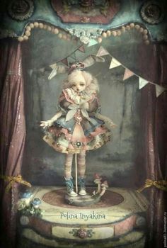 a painting of a doll on top of a table in front of a stage curtain