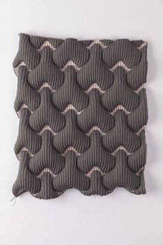 a piece of fabric with wavy lines on the top and bottom, in grey color