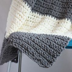 a crocheted blanket sitting on top of a metal chair