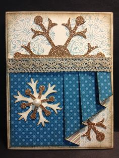 an altered christmas card with snowflakes and ribbons on the front, in blue