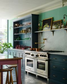 a kitchen with green walls and blue cabinets