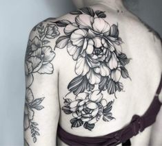 the back of a woman's shoulder with flowers on it