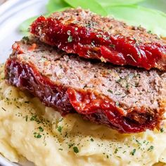 meatloaf and mashed potatoes on a white plate with garnishes