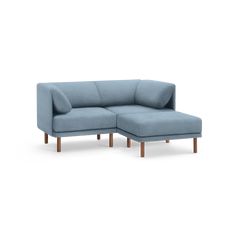 a blue sectional sofa with wooden legs and armrests on an isolated white background