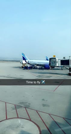 an airplane sitting on the tarmac at an airport with another plane in the background