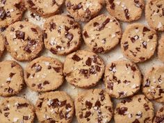 chocolate chip cookies with coconut flakes are on a baking sheet, ready to be eaten