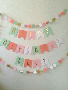 a happy birthday banner hanging on the wall with confetti and paper garlands