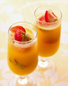 two glasses filled with drinks sitting on top of a table