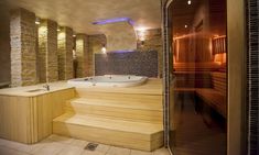 a bathroom with a jacuzzi tub next to a tiled wall and flooring