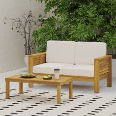 a white couch sitting next to a wooden coffee table on top of a tiled floor