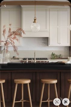 three stools in front of a kitchen counter with an island top and white cabinets