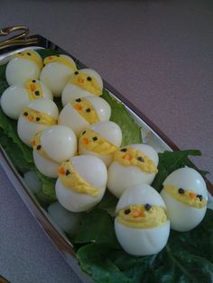 some kind of food that looks like eggs with chicks in them on top of leaves