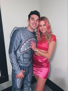 a man and woman dressed up in costumes posing for the camera with their arms around each other