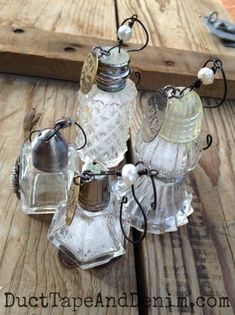 three glass salt and pepper shakers sitting on top of a wooden table