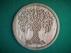 a wooden wall hanging with an intricate tree design on the front and back side,