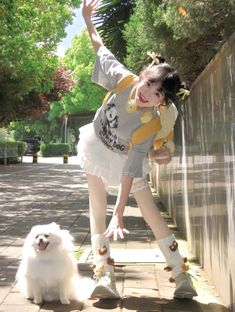 a woman is posing with her dog on the sidewalk