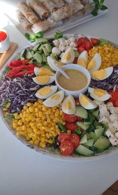 a platter filled with different types of vegetables and meats on top of a table