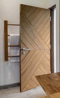 an open wooden door in a room with white walls and wood flooring on the side