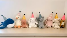 several stuffed animals are lined up on a shelf