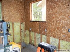 a room that is under construction with some insulation on the walls and tools in the foreground