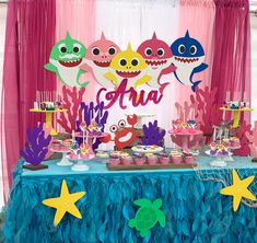 an under the sea themed birthday party with shark decorations and desserts on a table