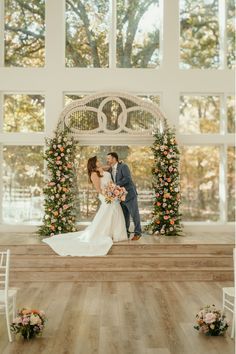 a bride and groom kissing on the alter