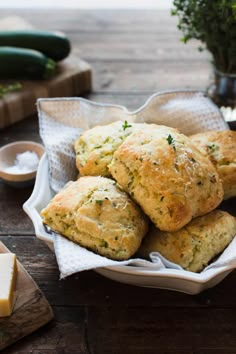 some biscuits are sitting on a plate with butter and parsley