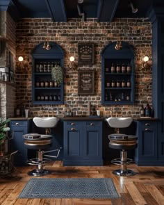 a bathroom with blue cabinets and two sinks in front of a brick wall that has lights on above it