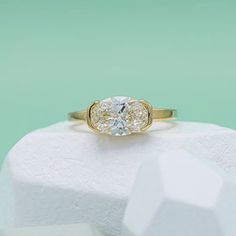 a close up of a ring on top of a white rock with a green background