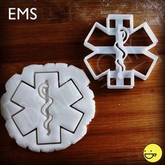 two cookie cutters shaped like medical symbols on a wooden table with a stethoscope