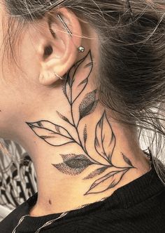 a woman's neck tattoo with leaves on it