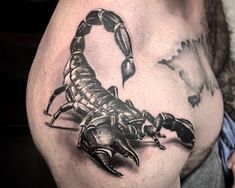 a man's chest with a scorpion tattoo on it, in black and white