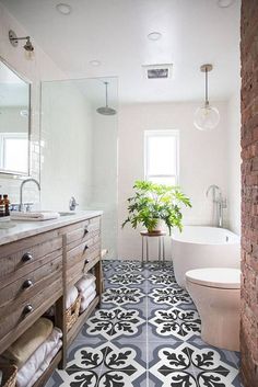 a bathroom with black and white tile flooring next to a bathtub, toilet and sink