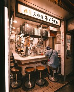 a person sitting at a counter in front of a restaurant