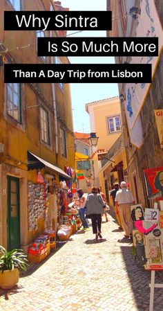 people walking down an alley way with buildings and signs on the walls that read, why santa is so much more than a day trip from lisbon