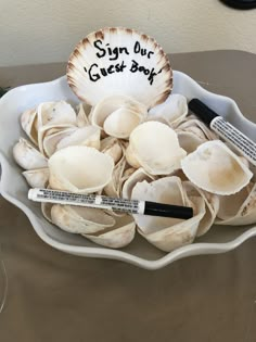 a bowl filled with lots of clams and writing on the side that says sign out guest book