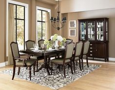 a dining room table with chairs and a china cabinet