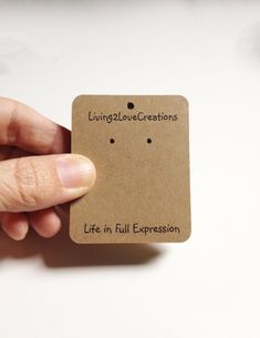 a person holding a piece of paper with the words livinglov creations written on it