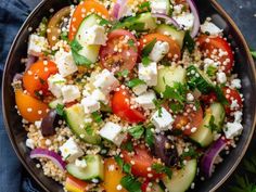 a salad with cucumbers, tomatoes, onions and feta cheese in a bowl