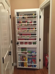 an organized pantry in the corner of a room with doors open to let food inside