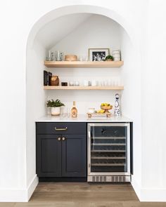 a kitchen with black cabinets and white walls