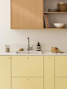 a kitchen with yellow cabinets and white counter tops